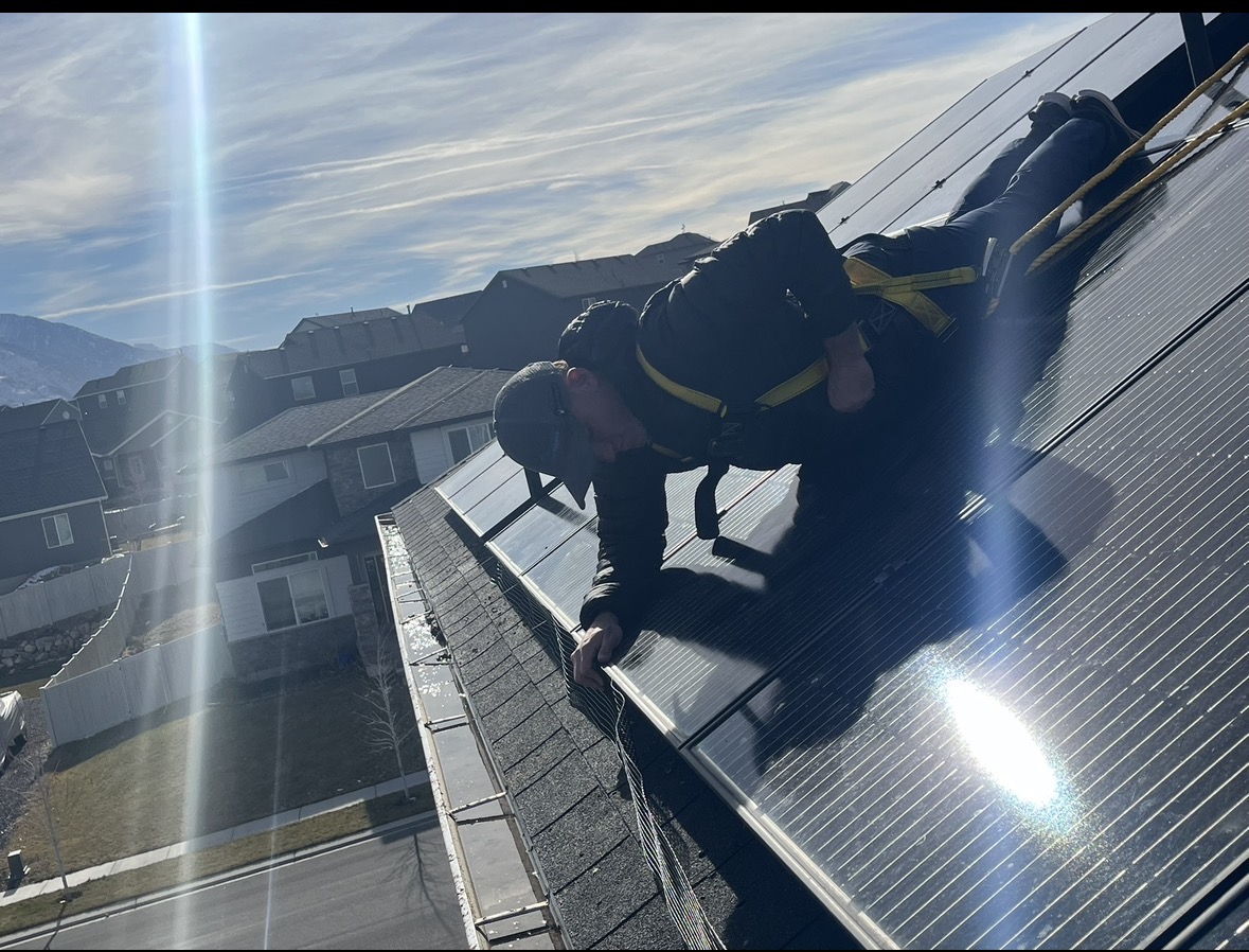 Professional pest control technician on roof with mountains